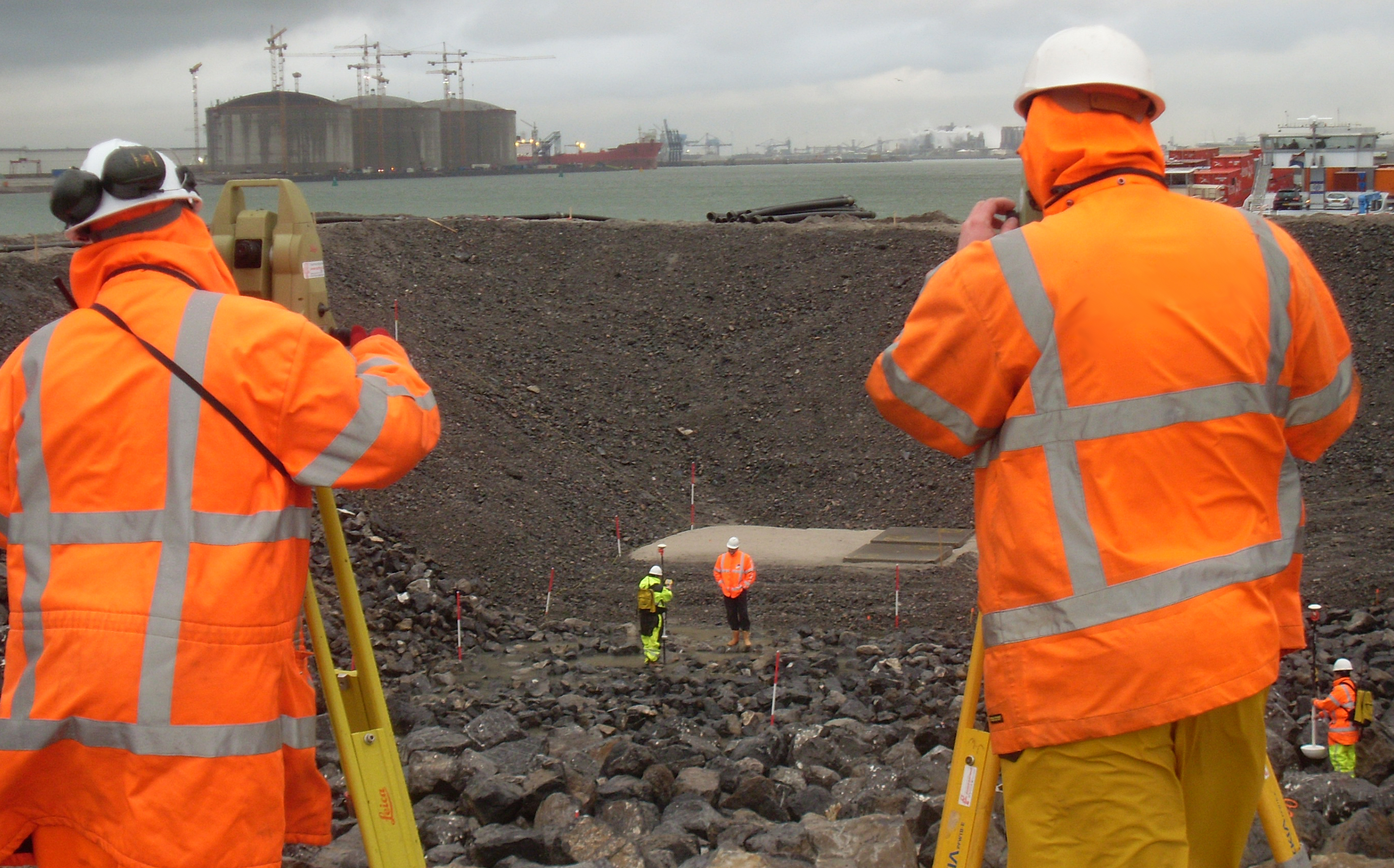 Landmeters aan het werk om een steenbestorting in te meten met diverse technieken als onderdeel van een onderzoek naar het verifiëren van steenbestortingen bij de aanleg van Maasvlakte 2.
